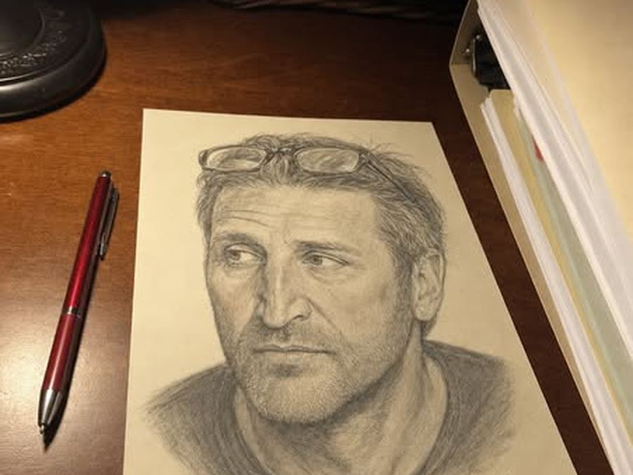 A finished pencil-style soulmate sketch lying on a desk